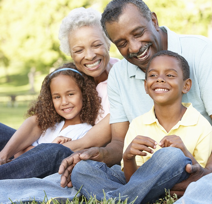 Grandparents and grandchildren smiling together outdoors