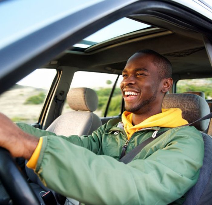 Man smiles while driving