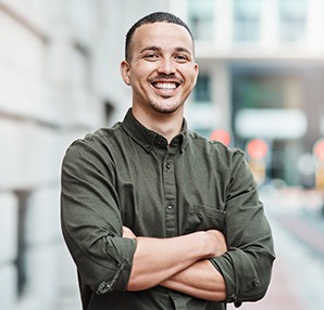 a smiling man with his arms crossed