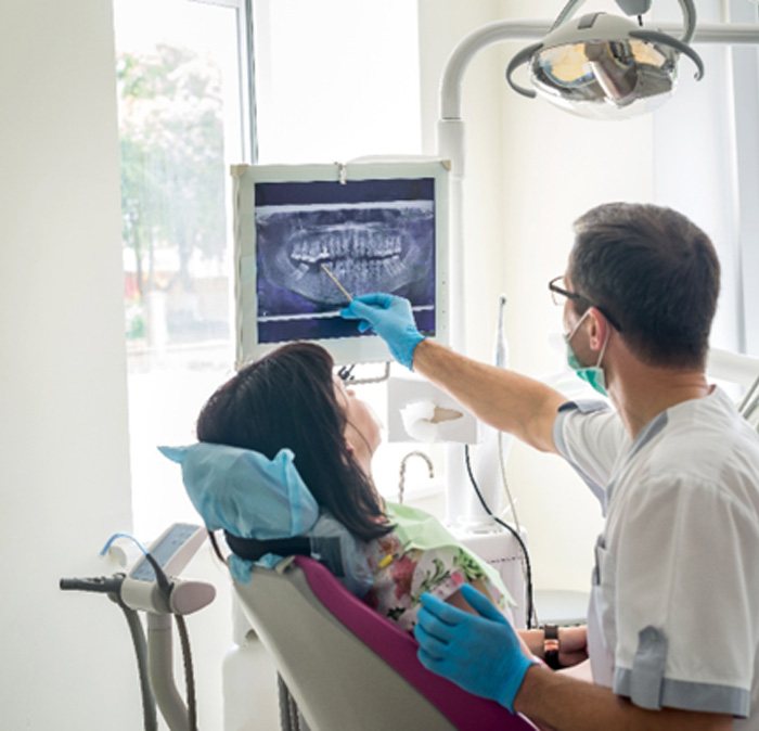 a dentist showing a patient their X-rays