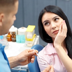 woman with a toothache talking to her emergency dentist in Houston