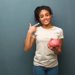 woman with piggy bank pointing to her smile