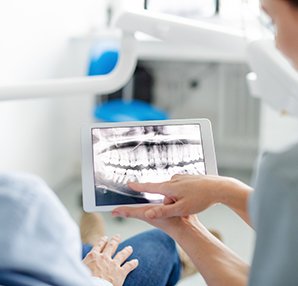a dental hygienist showing a patient his X-rays