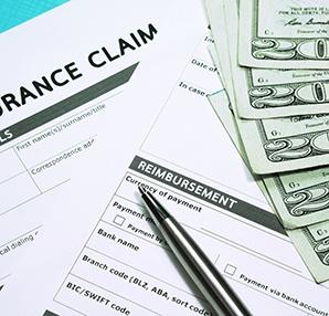 an empty dental insurance claim form with money on top of it