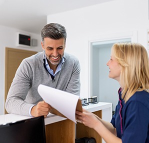 a patient speaking with a staff member at a dental office