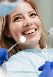 a patient smiling while undergoing a dental checkup and cleaning