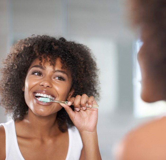 Woman using at home dental hygiene products