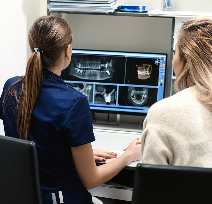 Dental team members looking at digital x-rays on computer screen